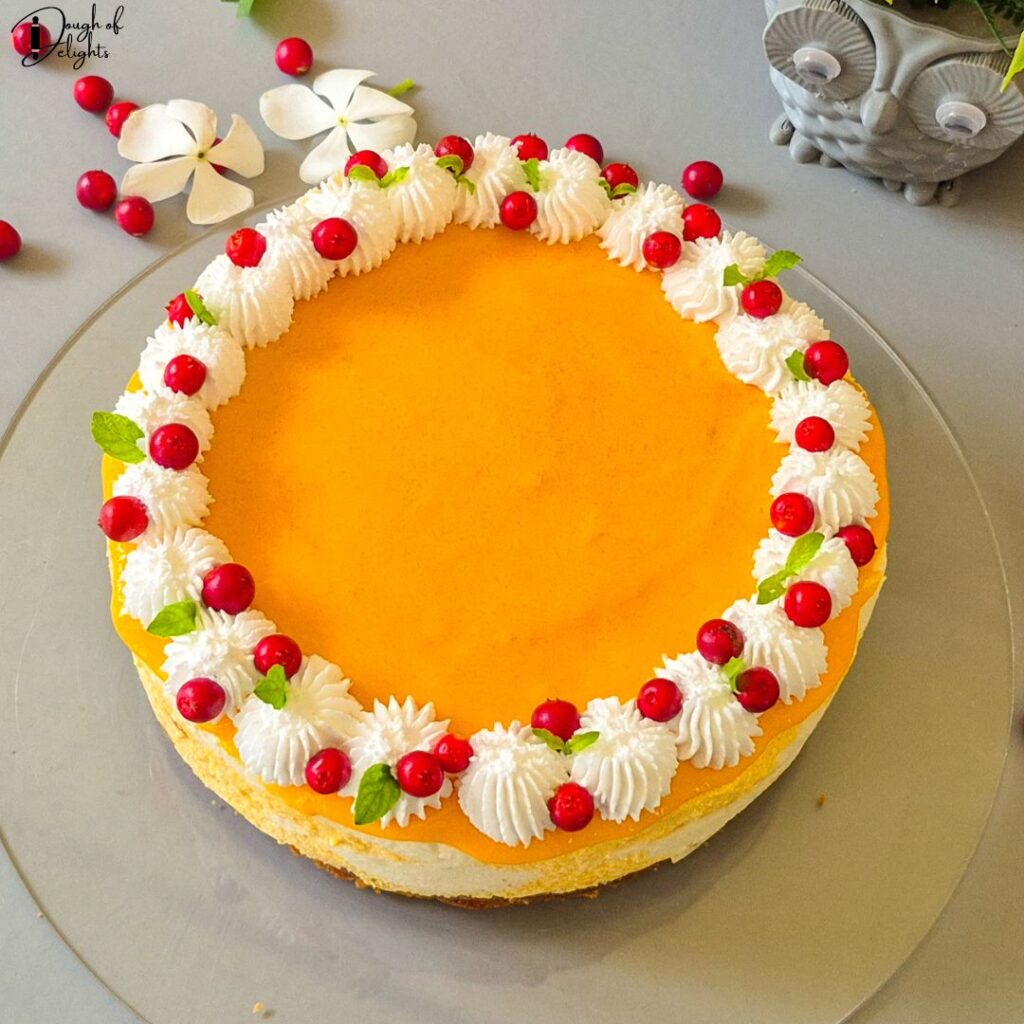 Easy No-bake mango coconut cheesecake topped with whipped cream and fresh mango pulp