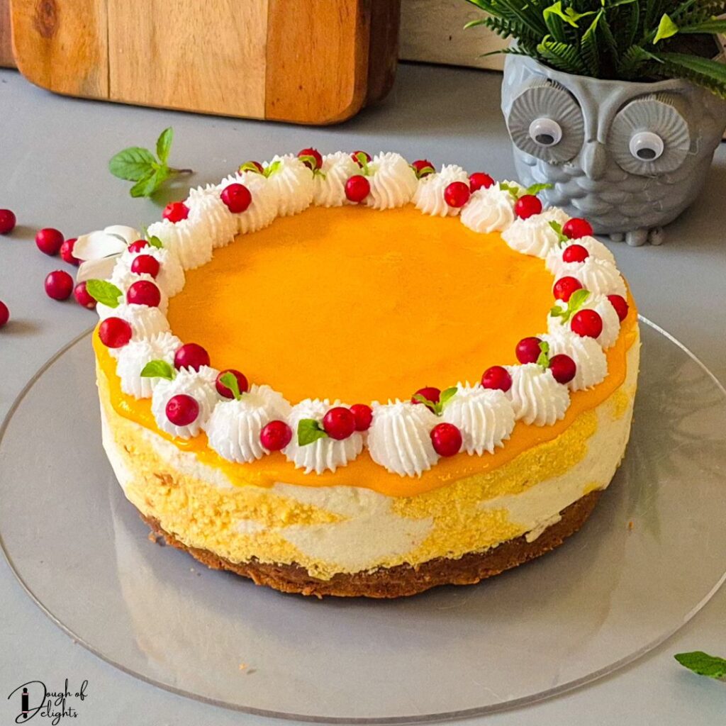 No-bake mango coconut cheesecake topped with whipped cream and fresh mango pulp