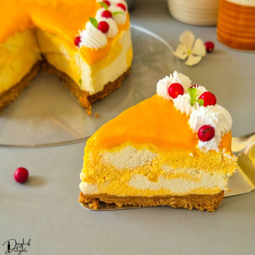 Slice of eggless mango cheesecake with a buttery biscuit base