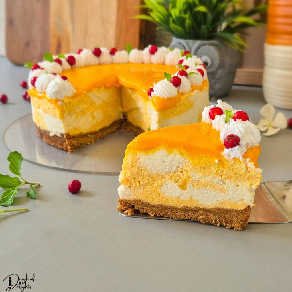 Creamy mango cheesecake slice topped with whipped cream and fresh fruit