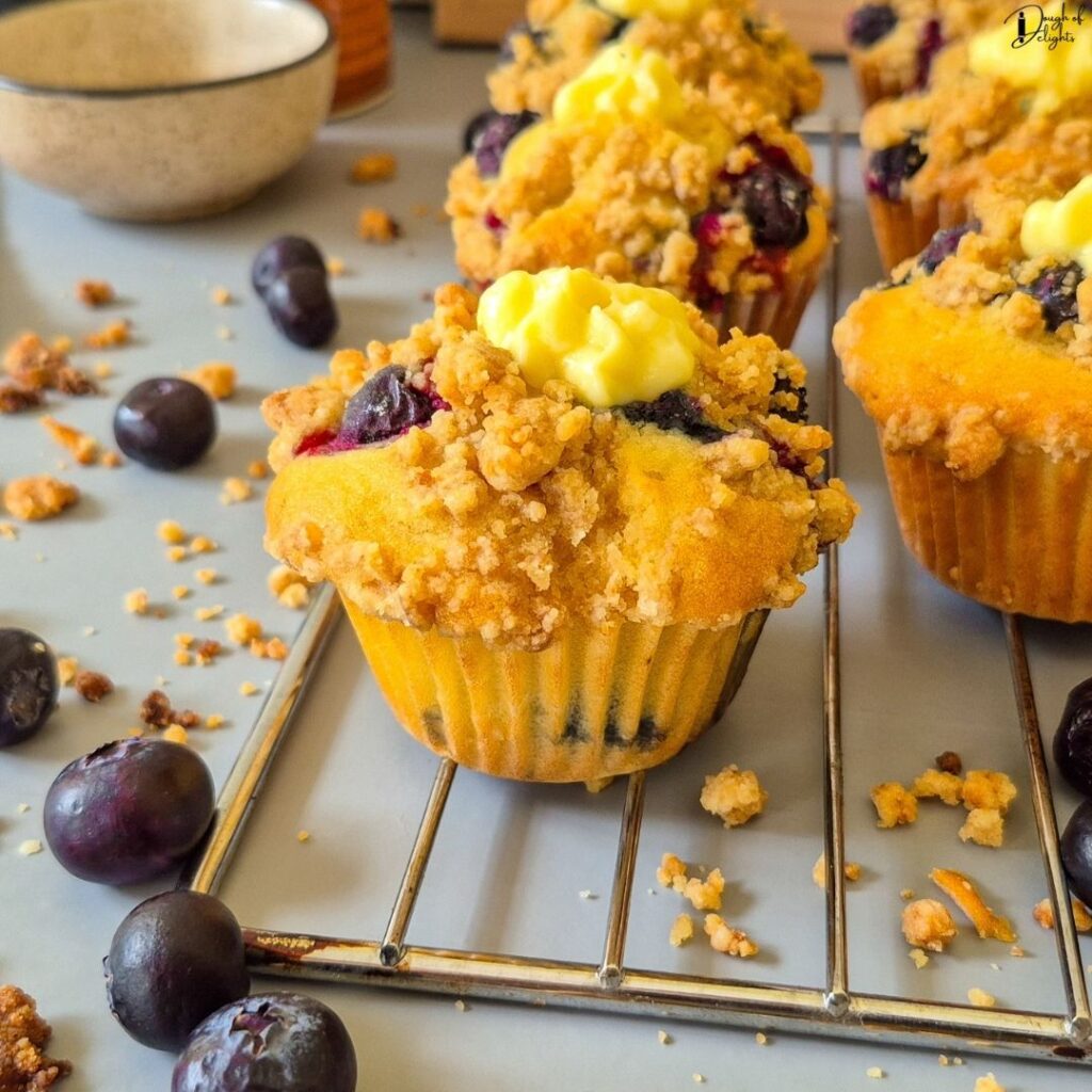 Blueberry Custard Crumble Muffins with a crisp crumble topping and smooth vanilla custard centre.