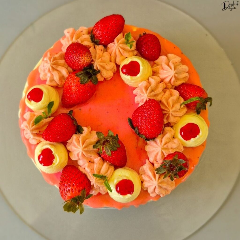 Fresh Strawberry Cake decorated with Swiss meringue buttercream, fresh strawberries, white chocolate, and mint leaves.