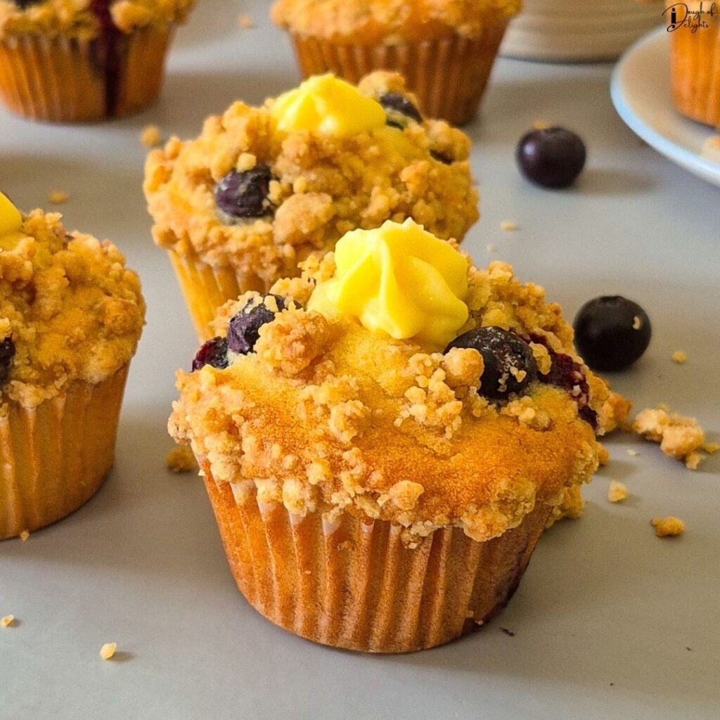 homemade Blueberry Custard Crumble Muffins showcasing their tall bakery-style tops and buttery crumble.