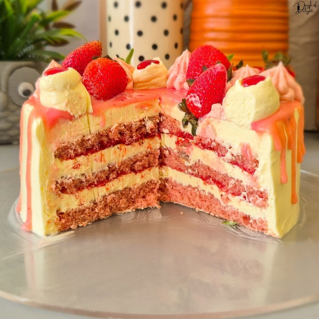 Cross-section of a homemade Strawberry Layer Cake with fluffy sponge, strawberry syrup, and silky buttercream.