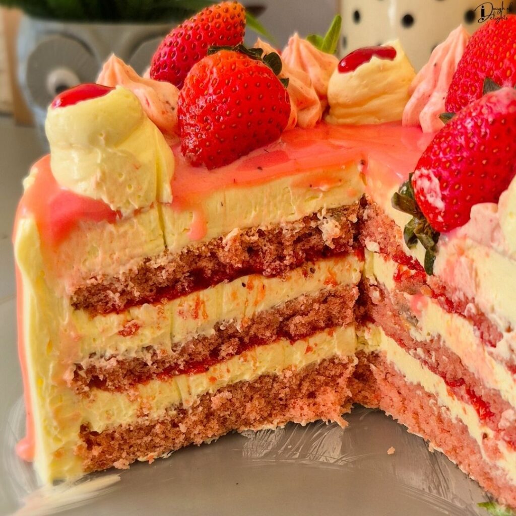 Cross-section of a Strawberry Layer Cake with fluffy sponge, strawberry syrup, and silky buttercream.