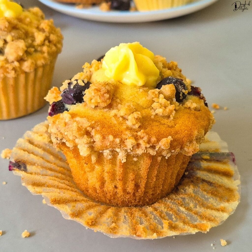 Blueberry muffin  topped with fresh blueberries and buttery crumble