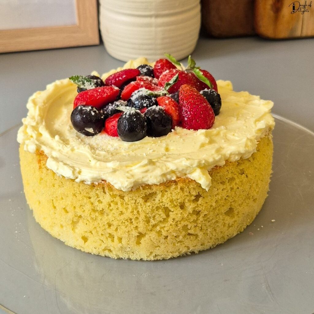 Soft and fluffy Coconut Sponge Cake decorated with fresh berries and creamy buttercream.