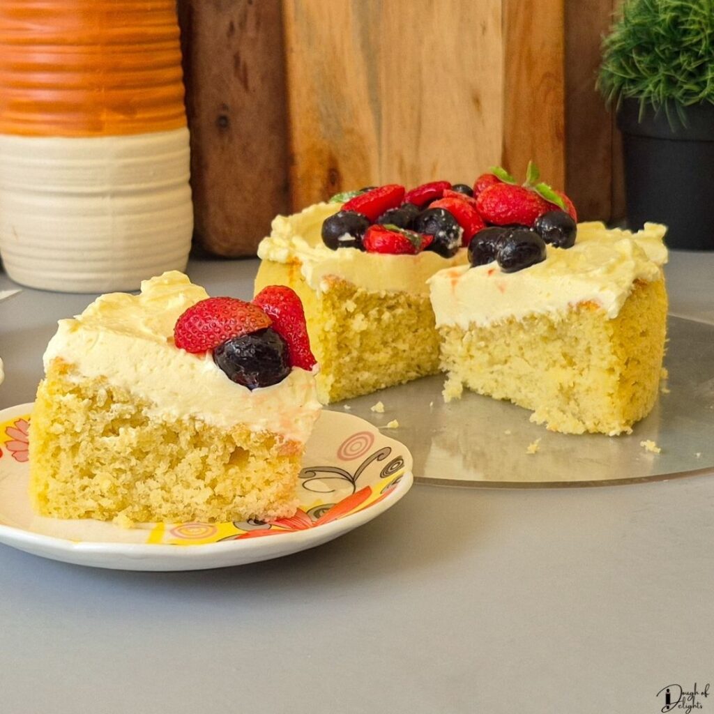 A slice of Coconut Sponge Cake showing its soft, fluffy interior and fine crumb.