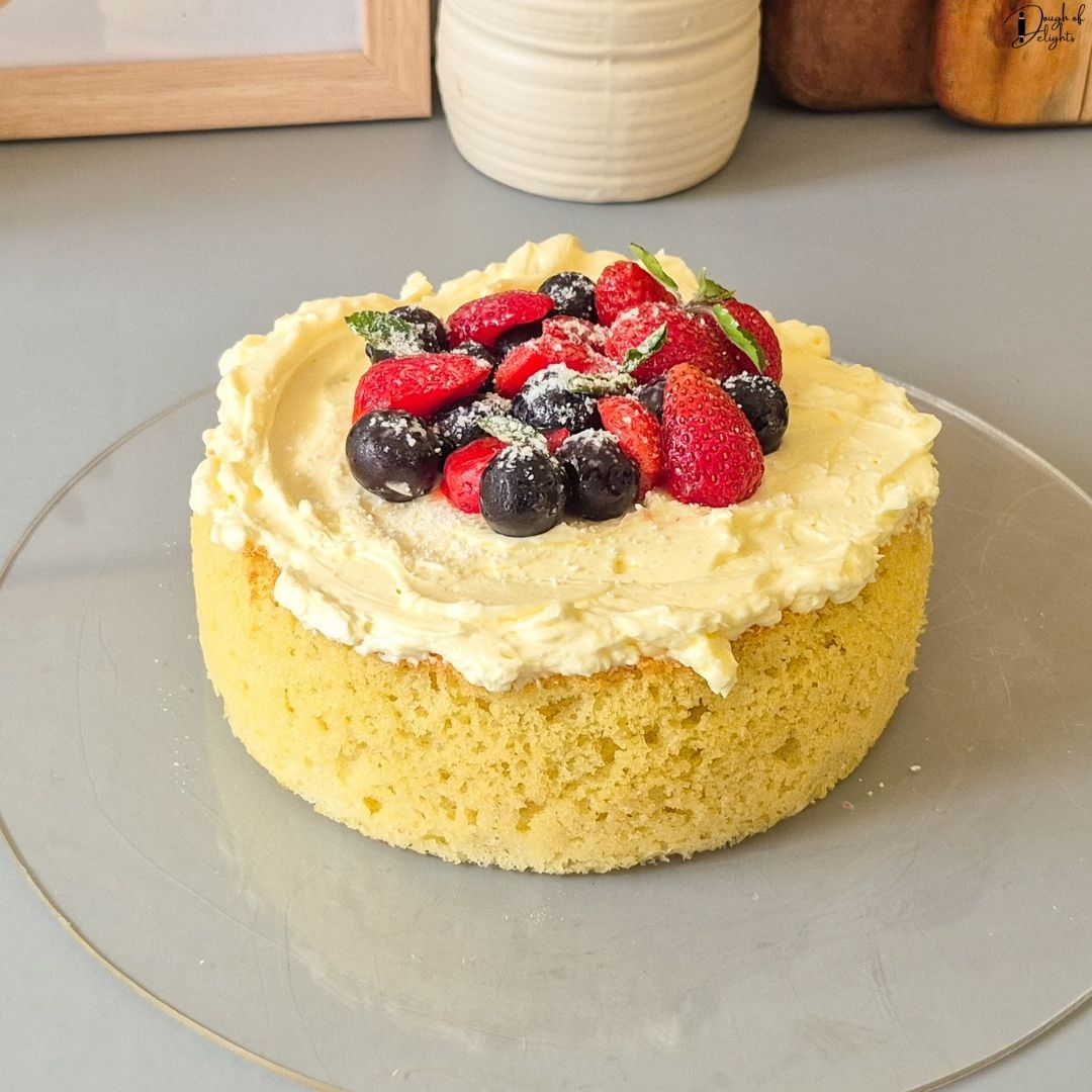 Elegant Coconut Sponge Cake with subtle coconut flavour, fluffy sponge, and fresh berry topping.